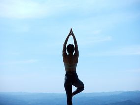 Femme en posture de yoga devant les montagnes