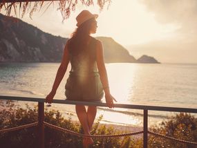 Femme au bord de la mer au coucher du soleil